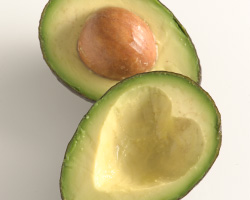 Two halves of a sliced avocado. The side without the pit is scooped in the shape of a heart.