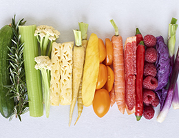 An assortment of fresh fruits and vegetables arranged to create a rainbow of colors.
